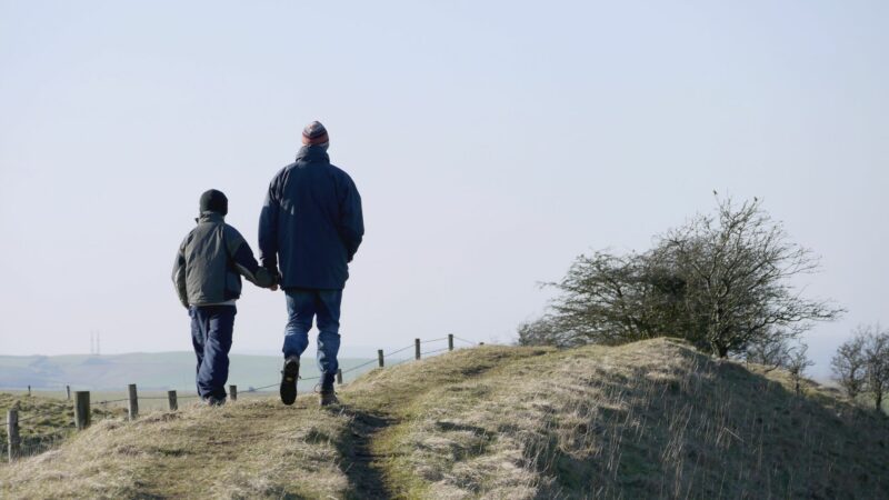 Father and son walking on road