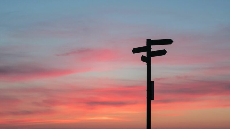 Sun setting on signposts
